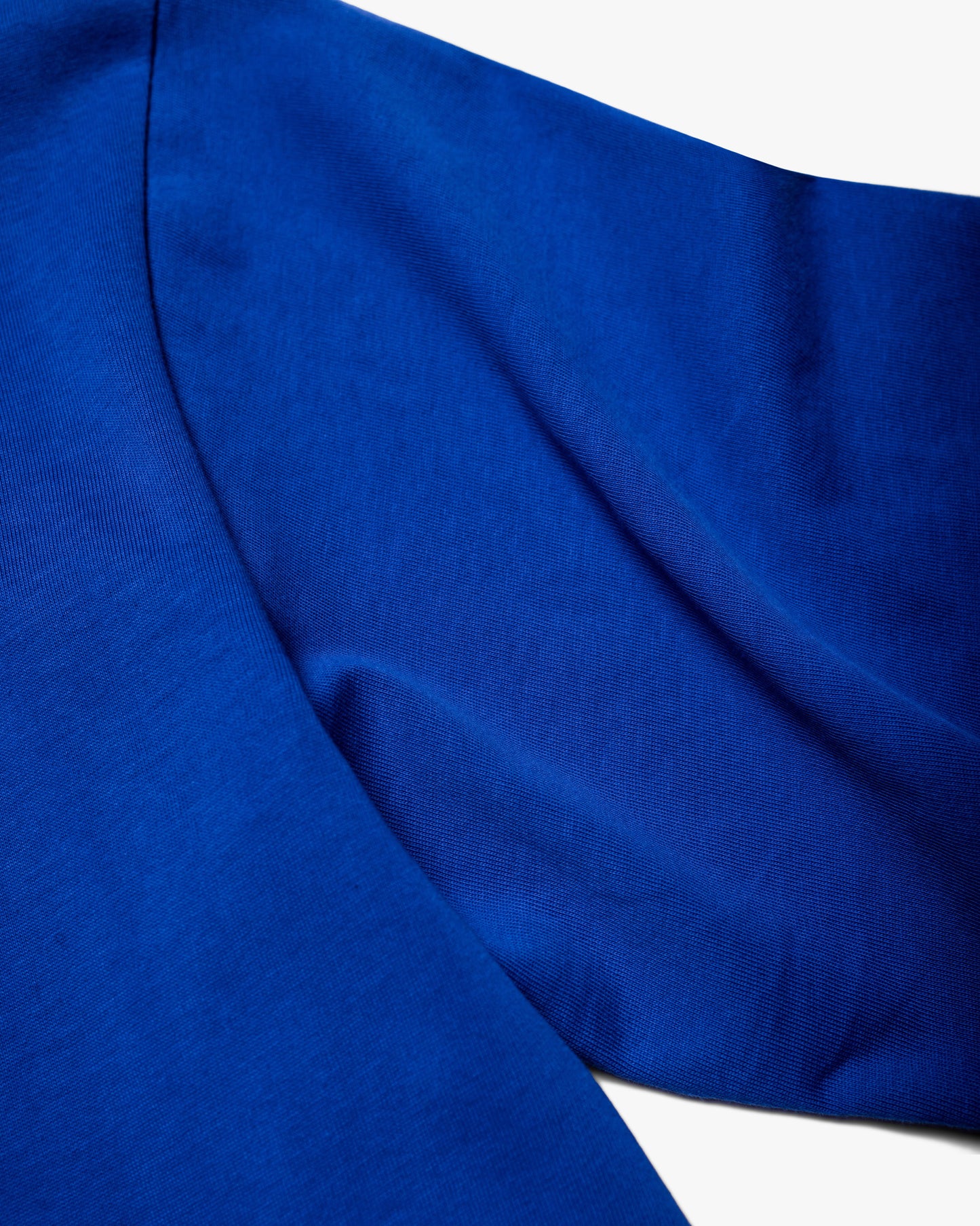 Close-up of high-quality material on the sleeve of blue T-shirt with floral embroidery