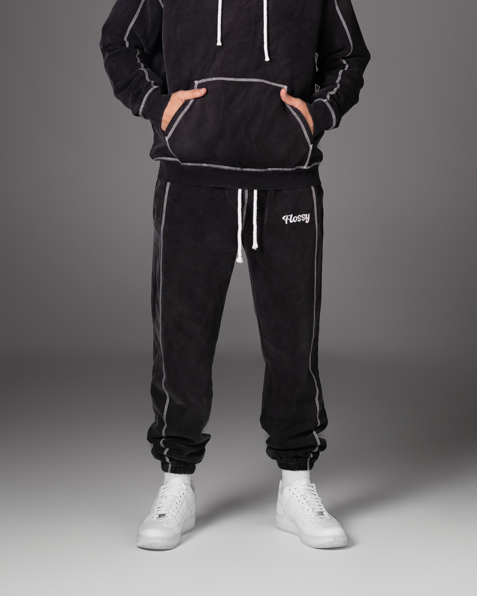 Flossy acid wash black joggers with rope drawstring and embroidered logo, front view